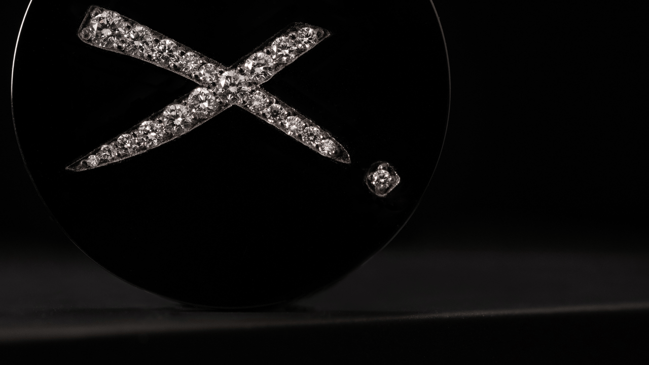 a black titanium and diamond luxury golf ball marker from Doubloon.