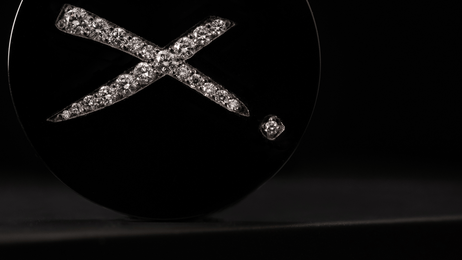 a black titanium and diamond luxury golf ball marker from Doubloon.