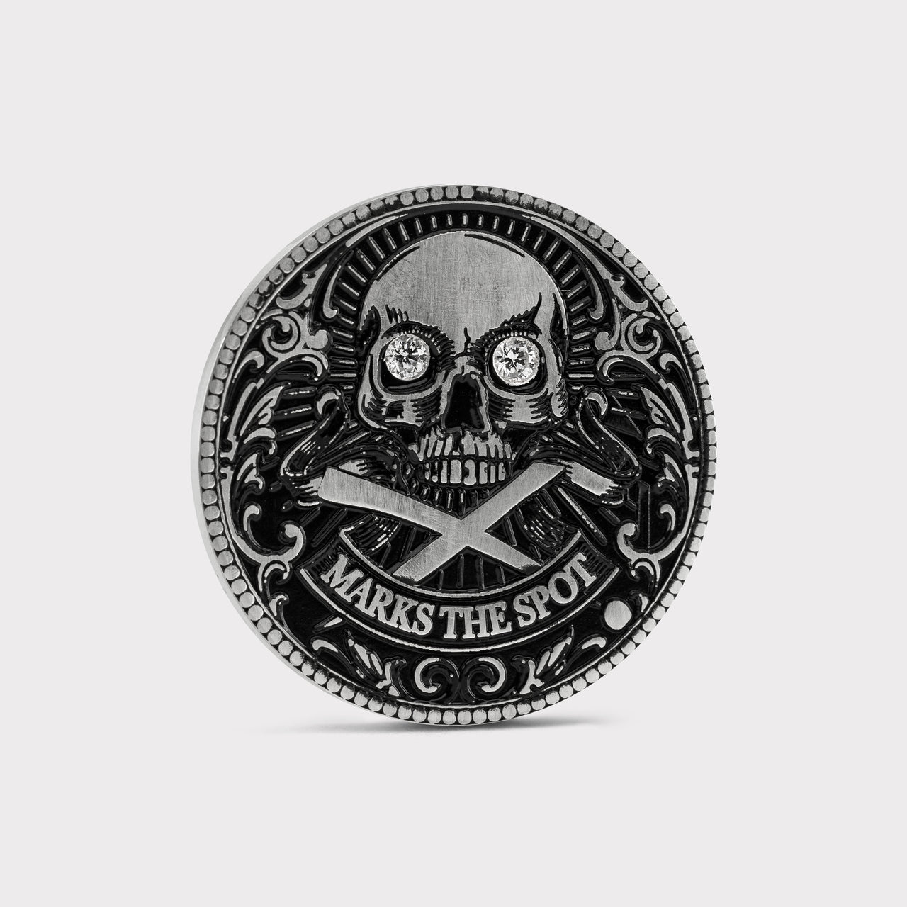 Decorative custom golf ball marker with skull design, diamonds in the eyes and 'X Marks the Spot' text on a white background