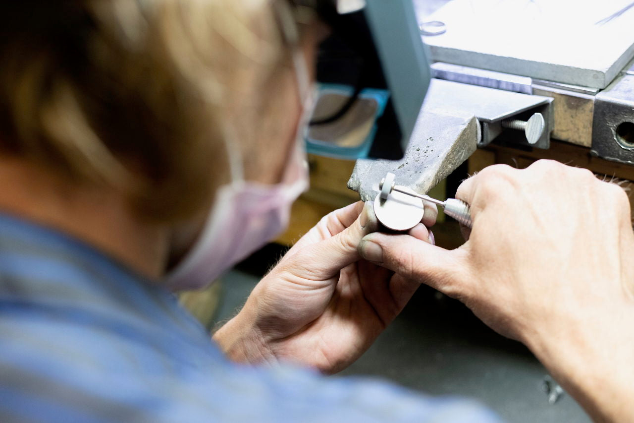 Jeweler crafting a Doubloon golf ball marker at the bench